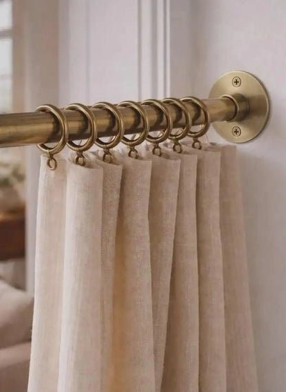 brass shower curtain rod with beige curtains