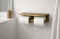 Wall mounted toilet paper holder with double brass shelf, showcasing elegance in a modern bathroom setting.