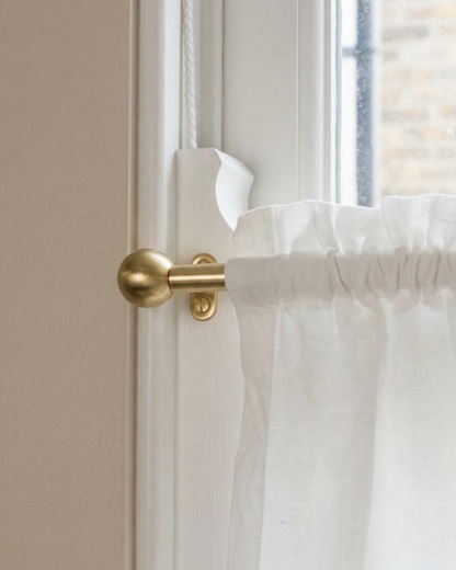 brass window rod with decorative finials