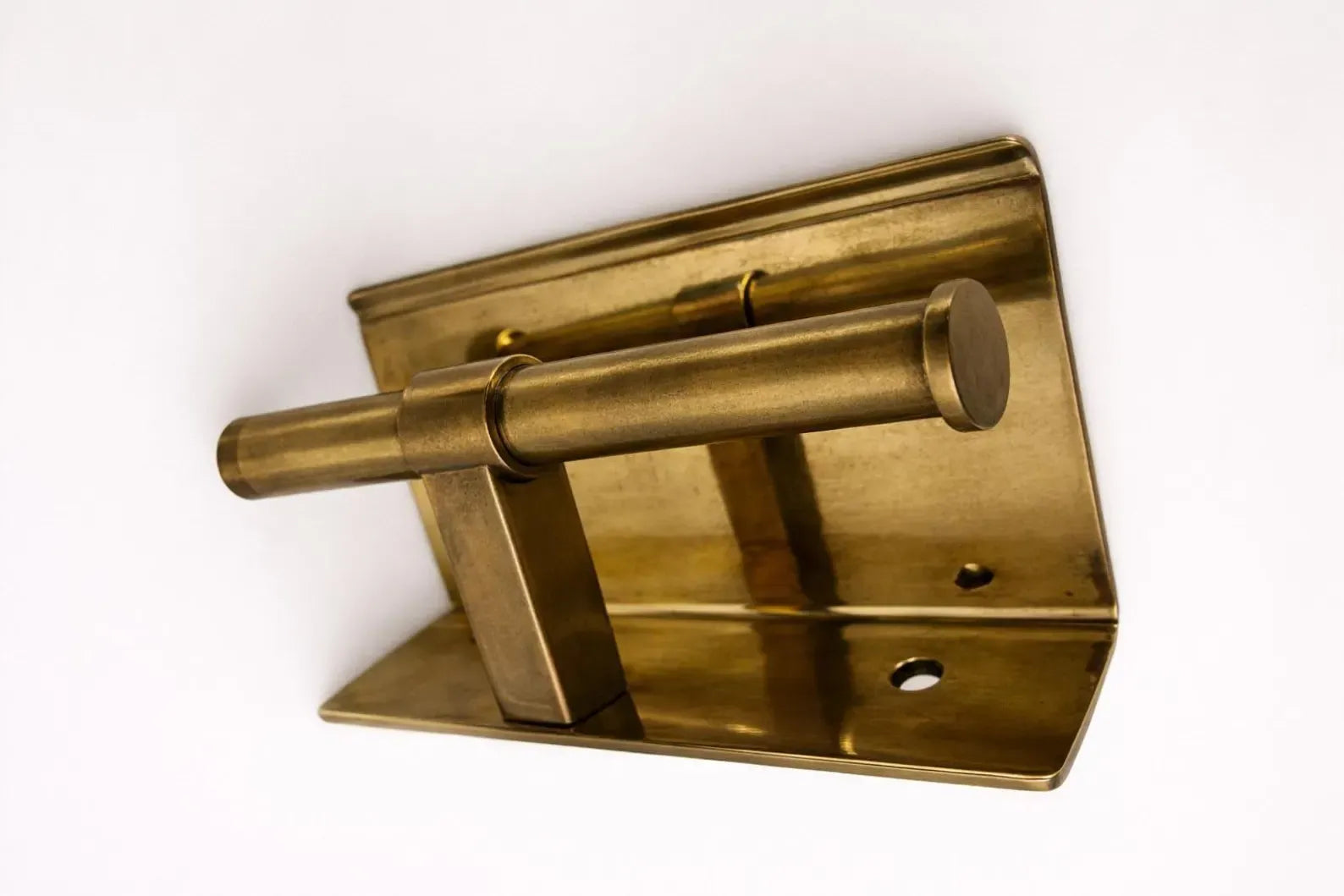 Wall mounted toilet paper holder with double brass shelf, showcasing elegance in a modern bathroom setting.